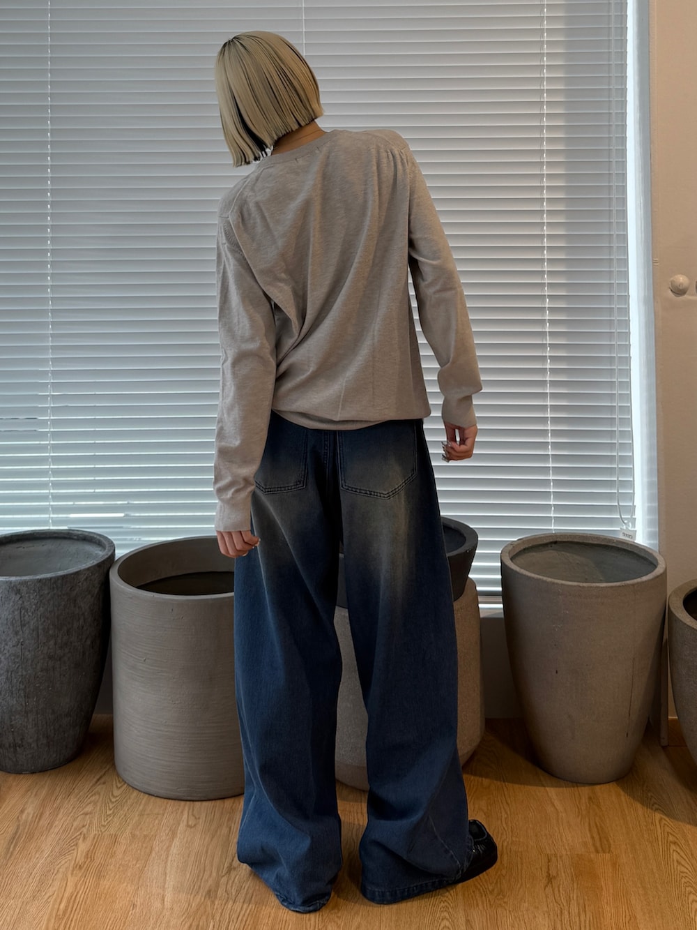 グレー系のニット/セーター、ブルー系のデニムパンツを着用したレディースの夏コーディネートの3枚目の写真