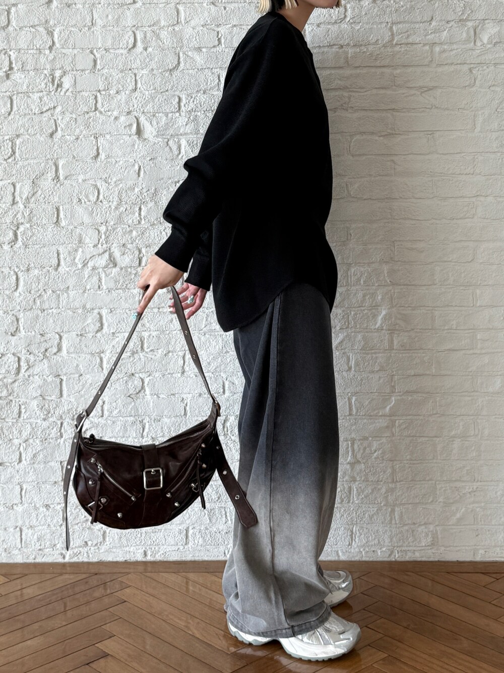 ブラック系のTシャツ/カットソー、ブラウン系のショルダーバッグ、ブラック系のデニムパンツを着用したレディースの夏コーディネートの2枚目の写真