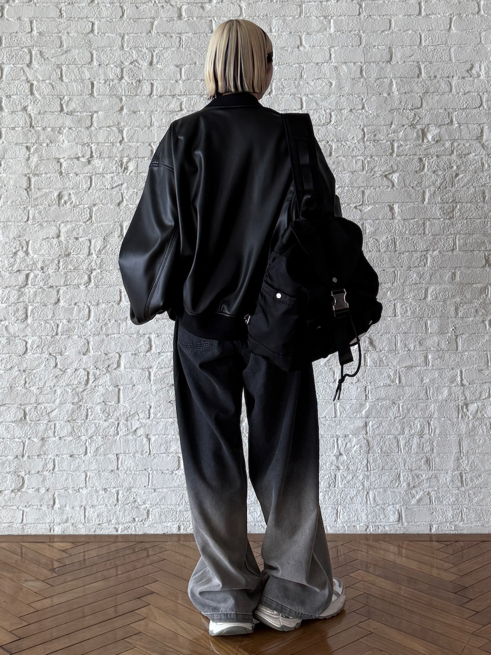 ブラック系のバックパック/リュック、ブラック系のブルゾン、ブラック系のデニムパンツを着用したレディースの夏コーディネートの2枚目の写真