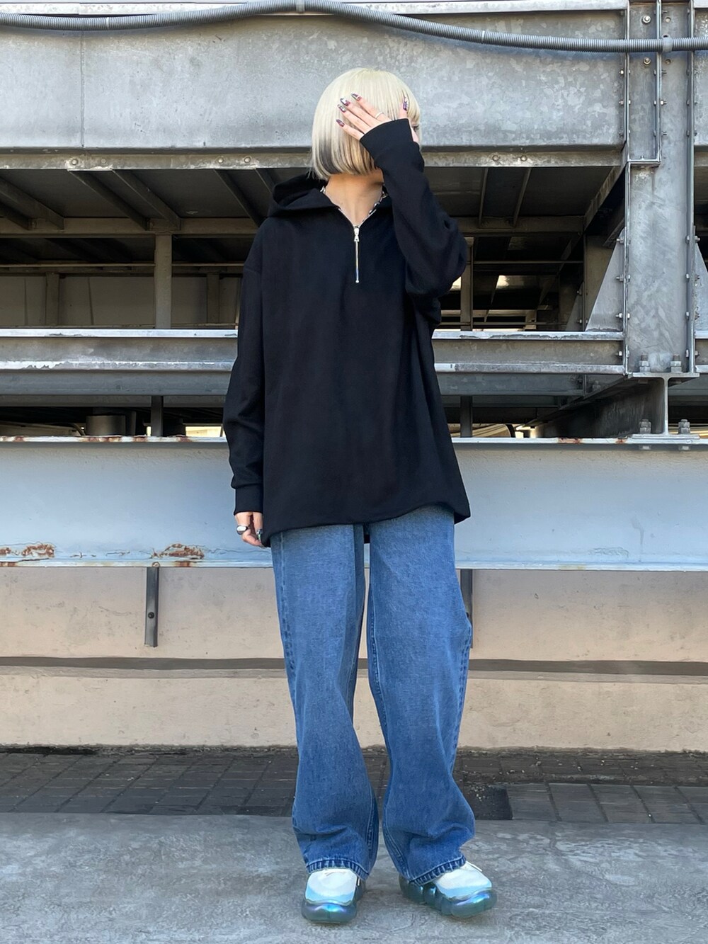 ブラック系のパーカー、ブルー系のデニムパンツを着用したレディースの冬コーディネートの2枚目の写真