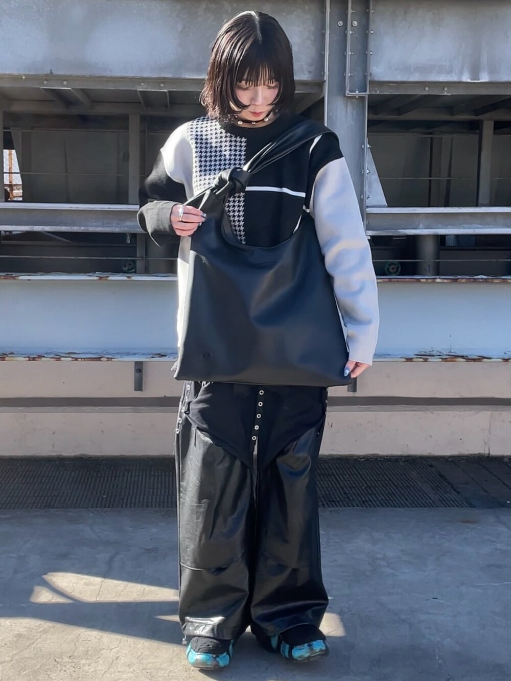 ブラック系のニット/セーター、ブラック系のショルダーバッグを着用したレディースの冬コーディネートの2枚目の写真