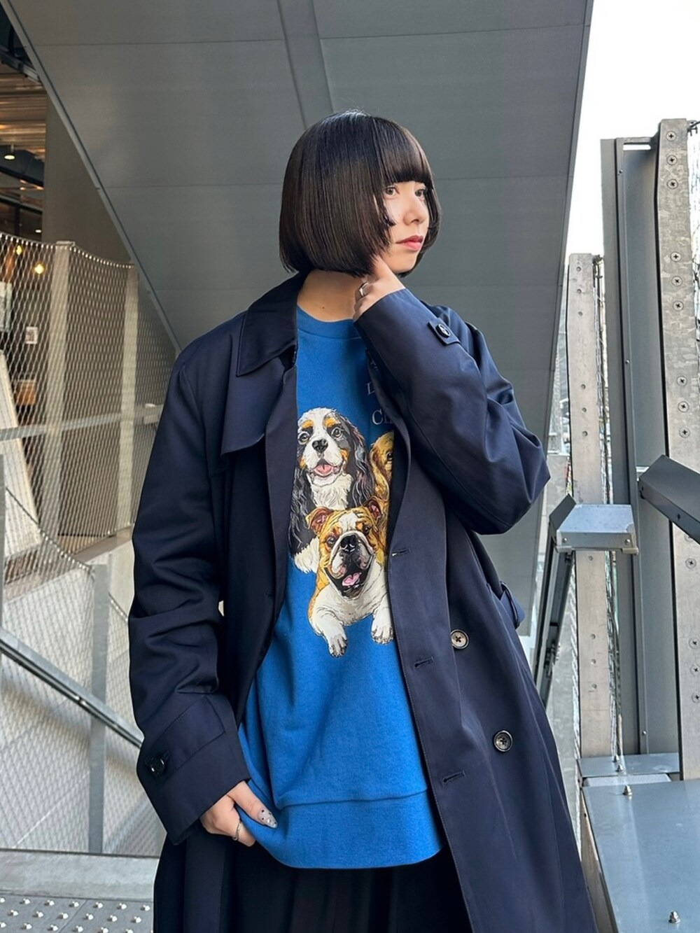 ブルー系のスウェット、ベージュ系のトレンチコートを着用したレディースの冬コーディネートの2枚目の写真