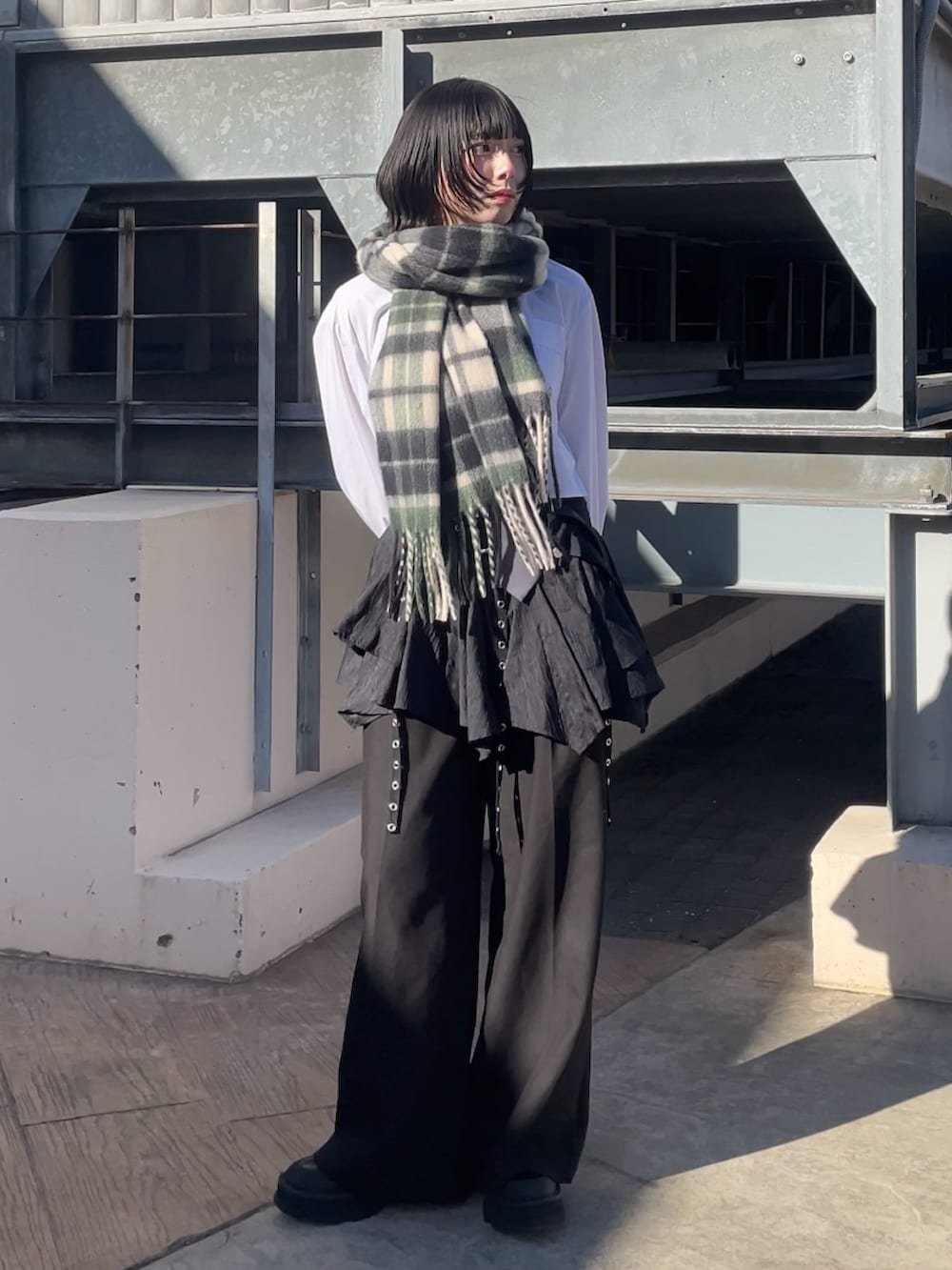 ブラック系のスラックス、グリーン系のマフラー、グリーン系のマフラーを着用したレディースの冬コーディネートの2枚目の写真