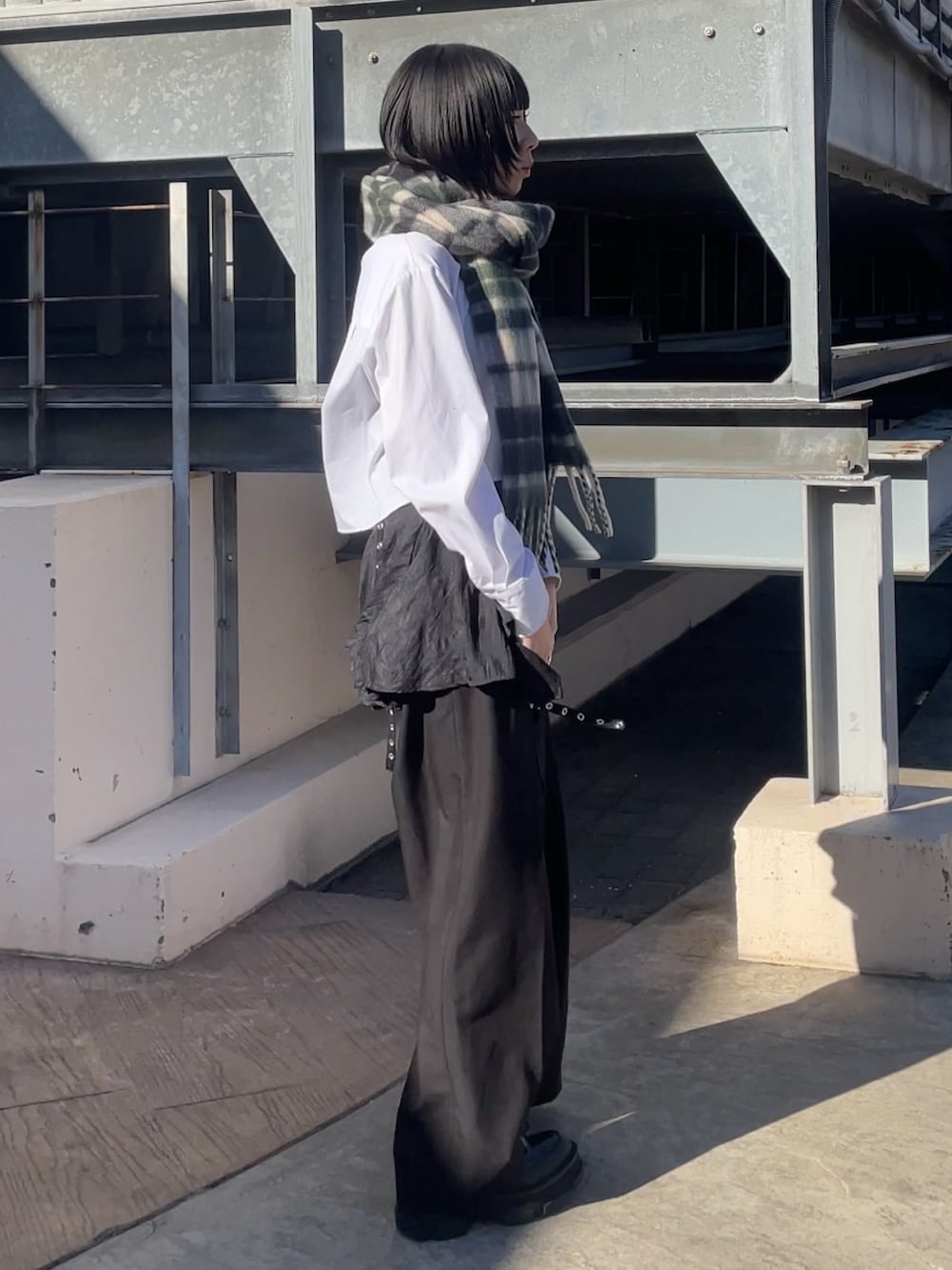 ブラック系のスラックス、グリーン系のマフラー、グリーン系のマフラーを着用したレディースの冬コーディネートの3枚目の写真