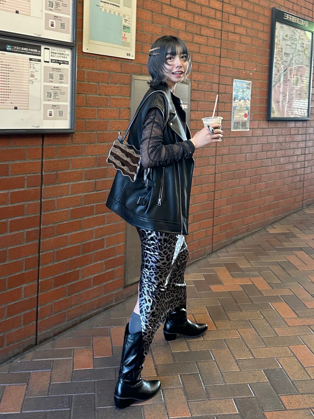 ブラック系のベスト、シルバー系のスカートを着用したレディースの春コーディネートの3枚目の写真