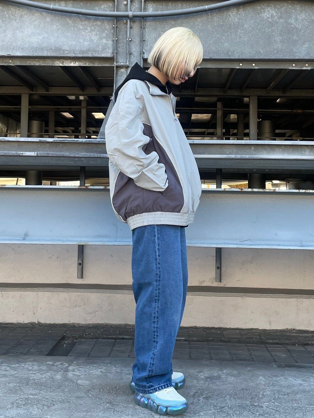 ブラック系のパーカー、グレー系のブルゾン、ブルー系のデニムパンツを着用したレディースの冬コーディネートの5枚目の写真