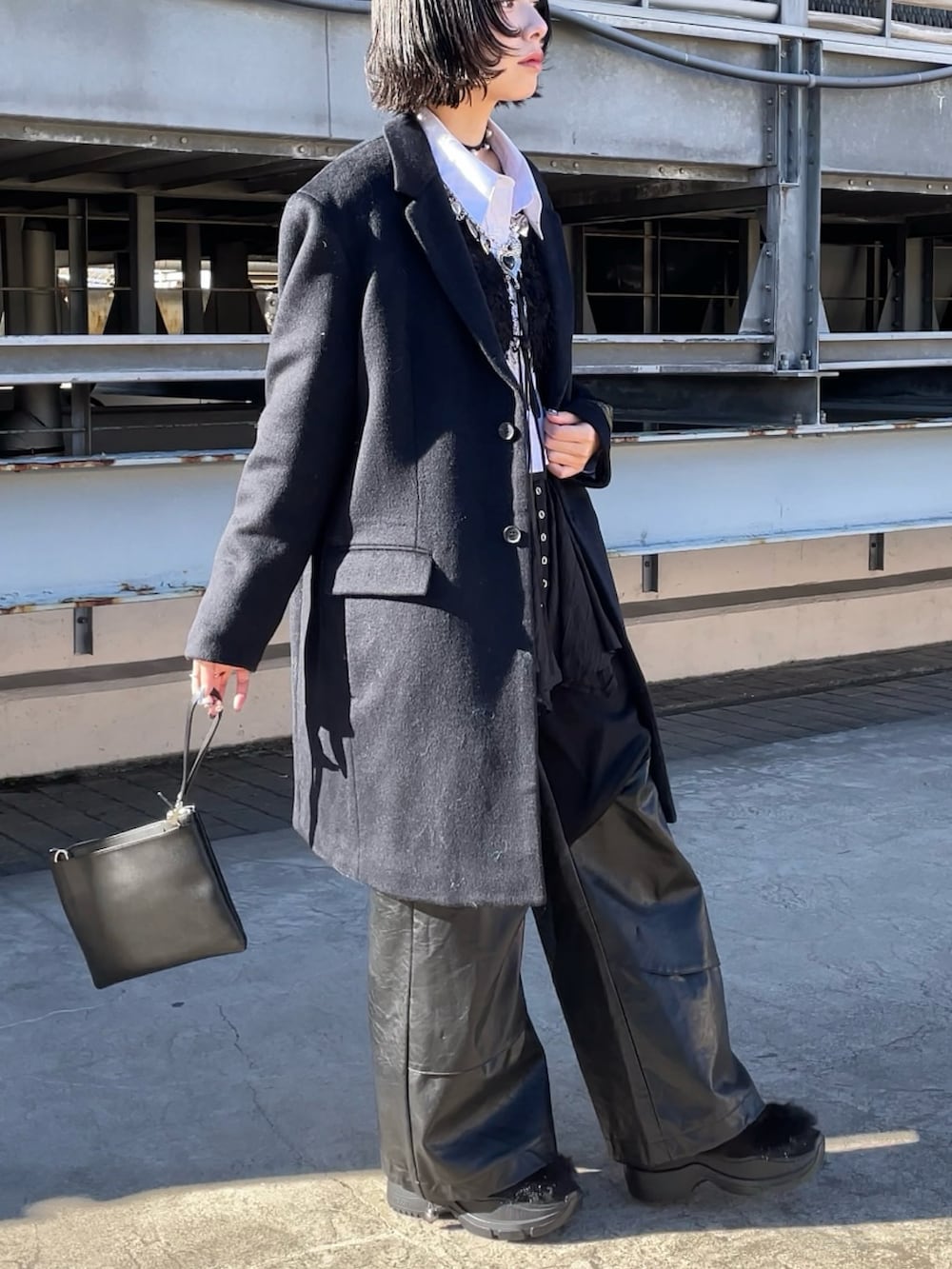 ブラック系のチェスターコート、ブラック系のショルダーバッグ、ブラック系のショルダーバッグを着用したレディースの冬コーディネートの3枚目の写真