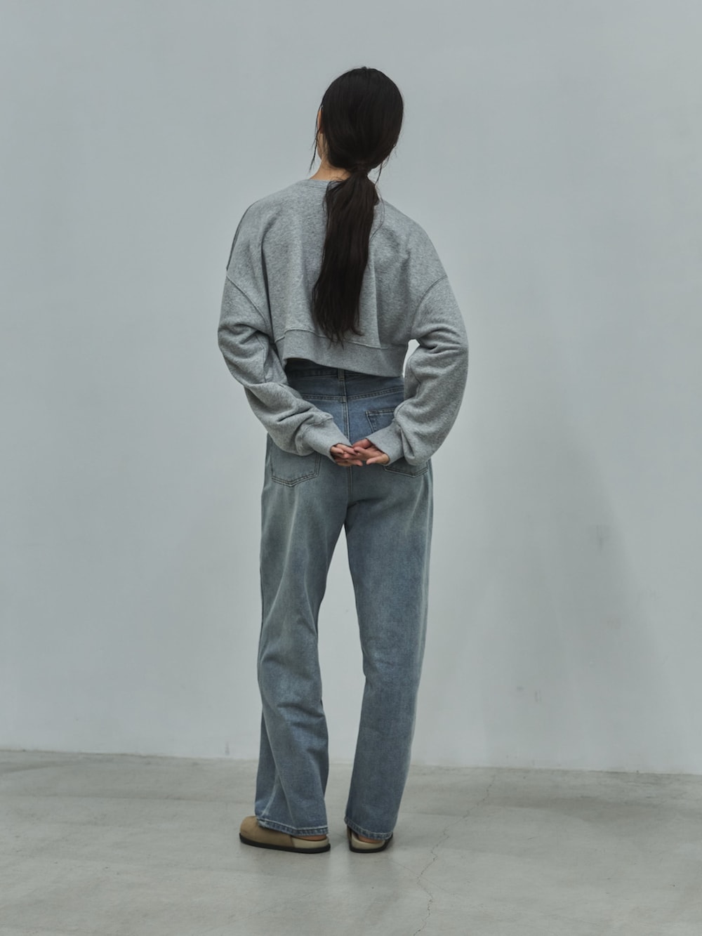 グレー系のスウェット、ブルー系のデニムパンツ、ベージュ系のその他シューズを着用したレディースの秋コーディネートの3枚目の写真
