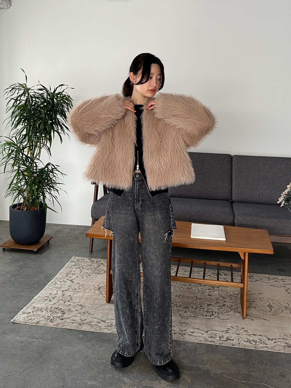 ブラック系のデニムパンツ、ベージュ系のその他アウター、ブラック系のニット/セーターを着用したレディースの冬コーディネートの2枚目の写真
