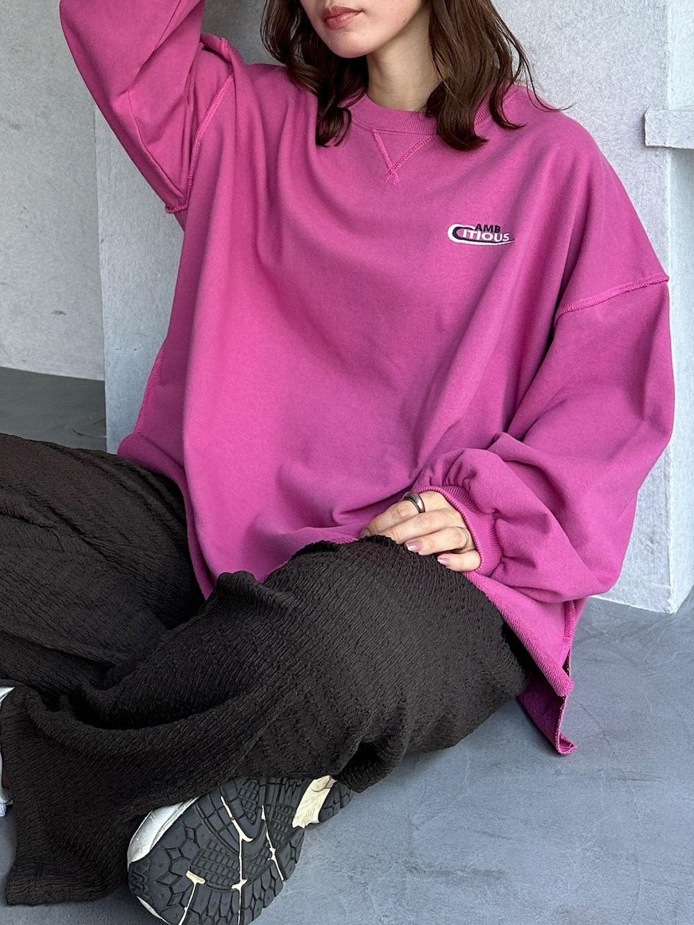 ピンク系のスウェット、ホワイト系のショルダーバッグ、ホワイト系のスニーカーを着用したレディースの冬コーディネートの4枚目の写真