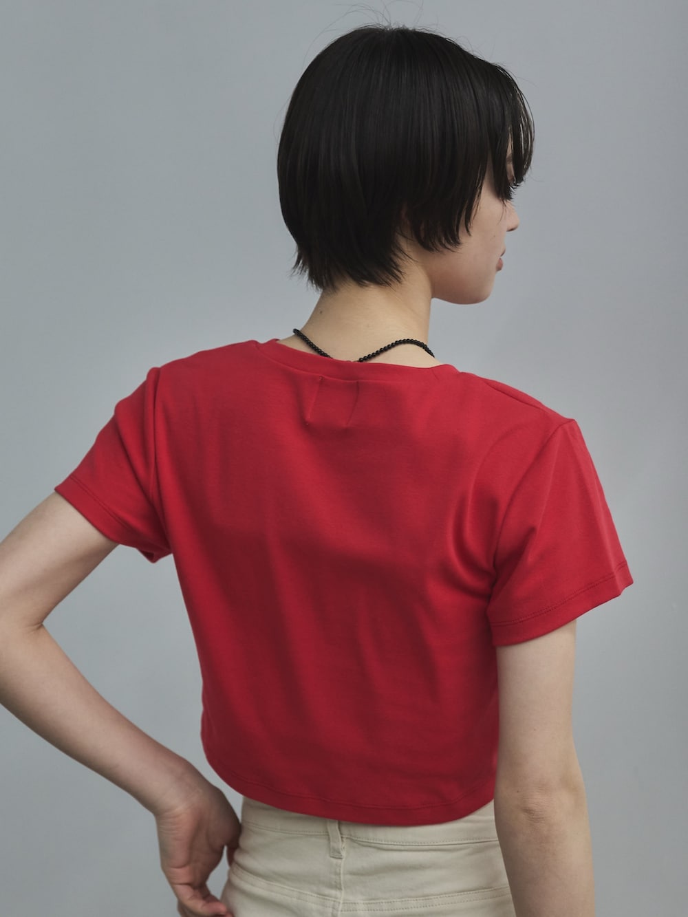 レッド系のTシャツ/カットソー、ホワイト系のデニムパンツ、ベージュ系のサンダルを着用したレディースの春コーディネートの6枚目の写真