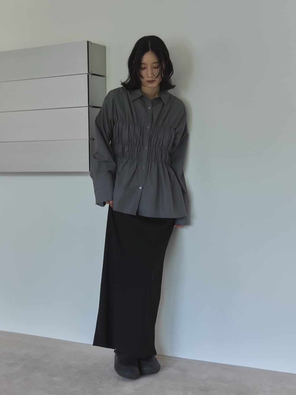 グレー系のシャツ/ブラウス、ブラック系のスカート、ブラック系のサンダルを着用したレディースの夏コーディネートの3枚目の写真