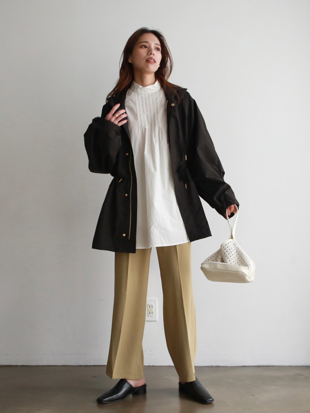 ホワイト系のTシャツ/カットソー、ブラック系のマウンテンパーカー、グレー系のスカートを着用したレディースの冬コーディネートの2枚目の写真