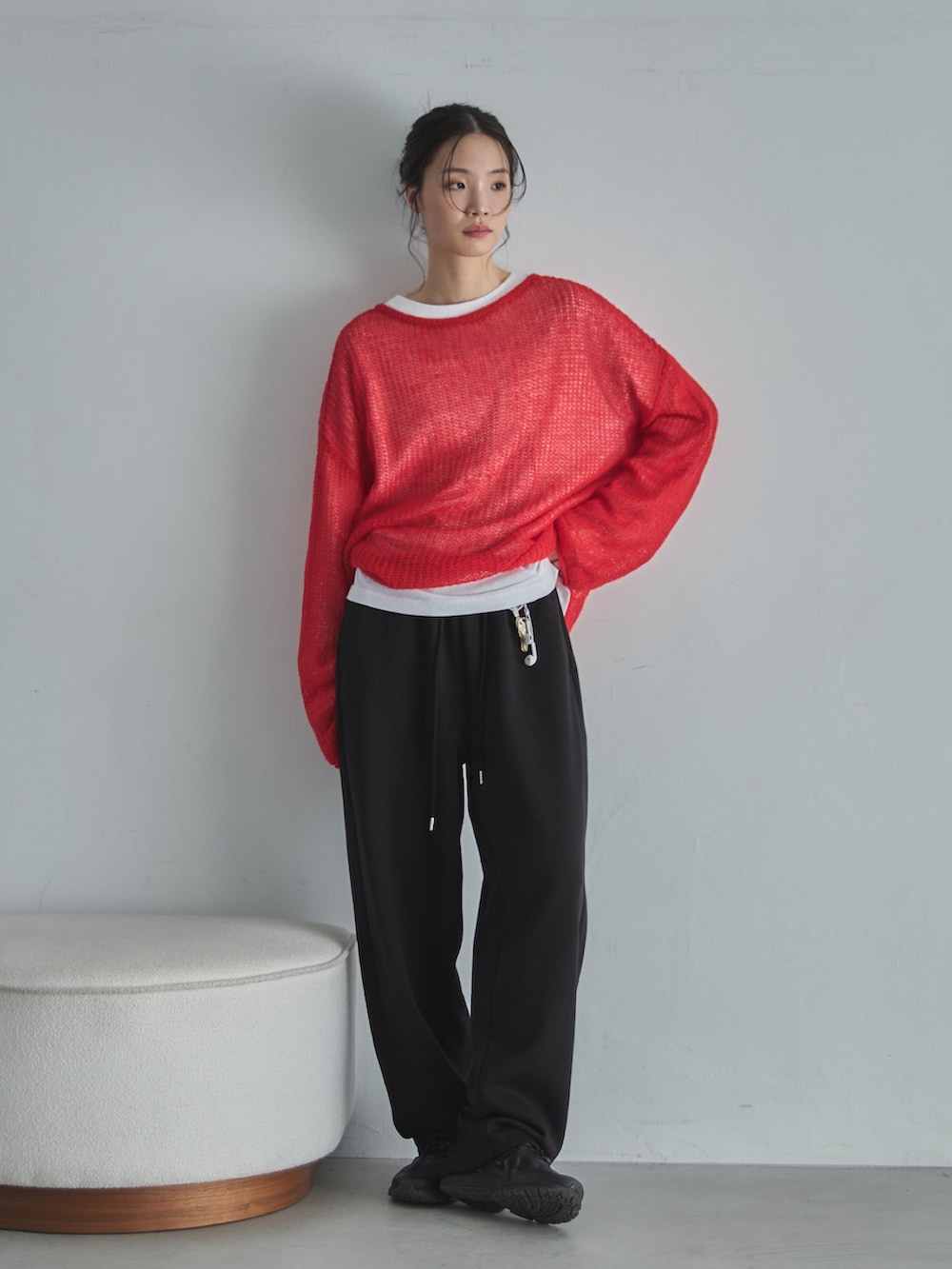 ホワイト系のTシャツ/カットソー、レッド系のニット/セーター、ブラック系のスウェットパンツを着用したレディースの冬コーディネートの3枚目の写真