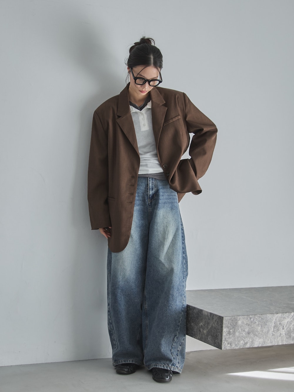 ブルー系のデニムパンツ、ブラウン系のテーラードジャケット、グレー系のTシャツ/カットソーを着用したレディースの春コーディネートの3枚目の写真