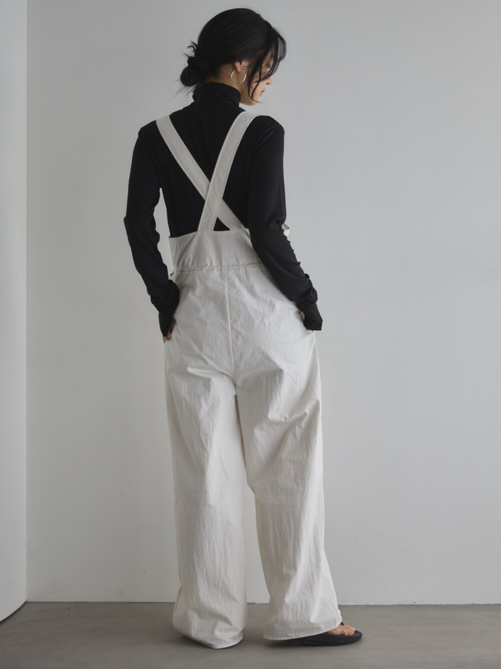 ブラック系のTシャツ/カットソー、ブラック系のサンダル、ホワイト系のサロペット/オーバーオールを着用したレディースの春コーディネートの3枚目の写真