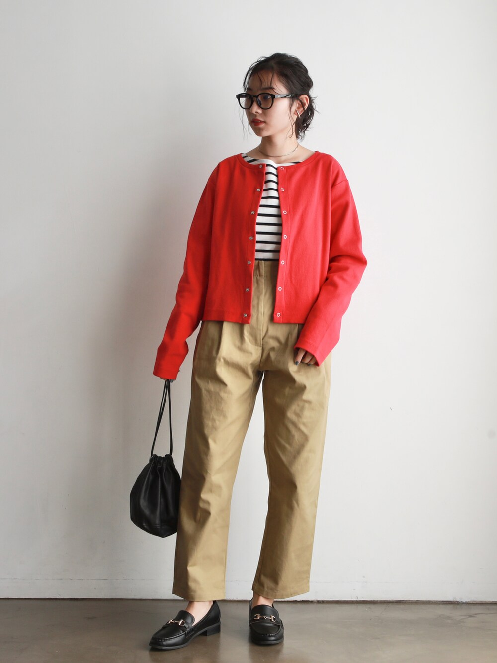 ブラック系のハンドバッグ、レッド系のカーディガン/ボレロ、ホワイト系のTシャツ/カットソーを着用したレディースの冬コーディネートの2枚目の写真