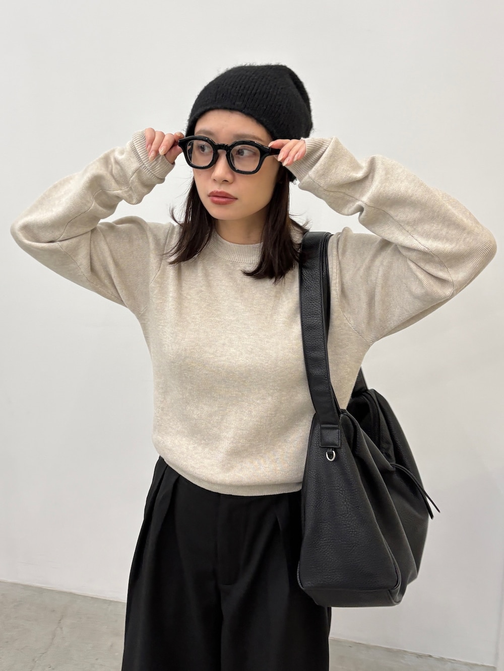 ホワイト系のニット/セーター、ブラック系のショルダーバッグ、ブラック系のその他パンツを着用したレディースの秋コーディネートの3枚目の写真