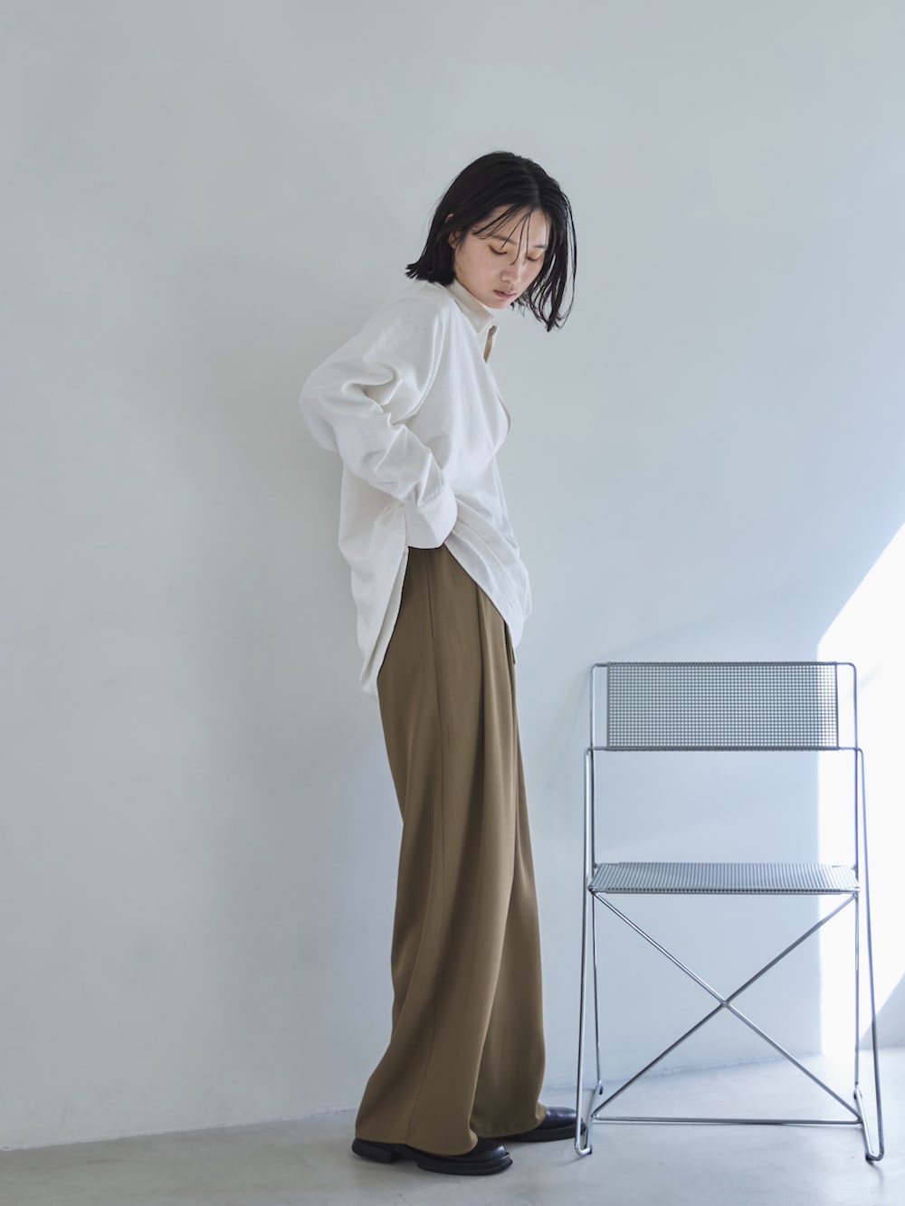 ホワイト系のシャツ/ブラウス、ベージュ系のスラックス、ブラック系のスリッポンを着用したレディースの春コーディネートの4枚目の写真