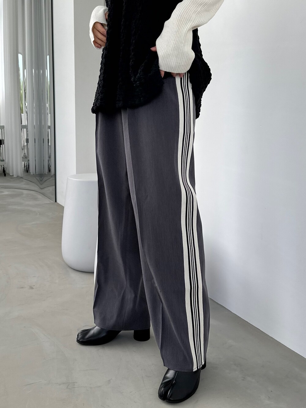 ブラック系のシャツ/ブラウス、グレー系のスラックス、ブラック系のブーツを着用したレディースの秋コーディネートの4枚目の写真