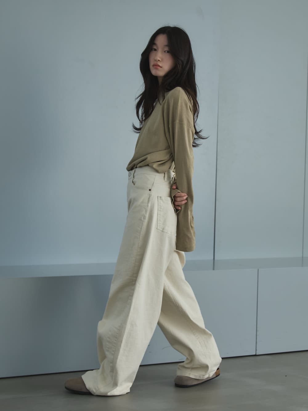 ブラウン系のTシャツ/カットソー、ホワイト系のデニムパンツ、ベージュ系のサンダルを着用したレディースの春コーディネートの2枚目の写真