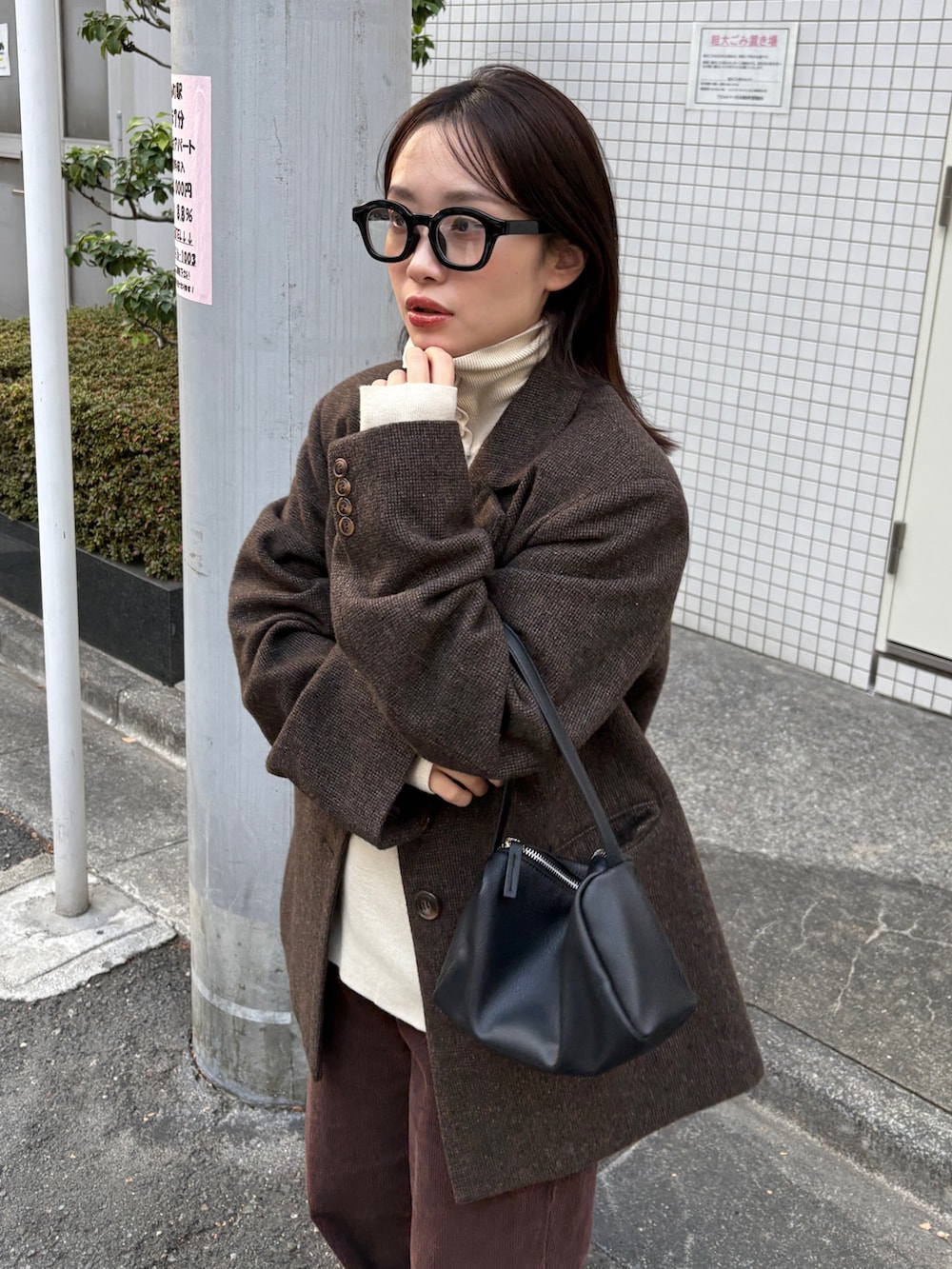 ブラウン系のテーラードジャケット、ブラック系のショルダーバッグ、ブラウン系のその他パンツを着用したレディースの冬コーディネートの3枚目の写真