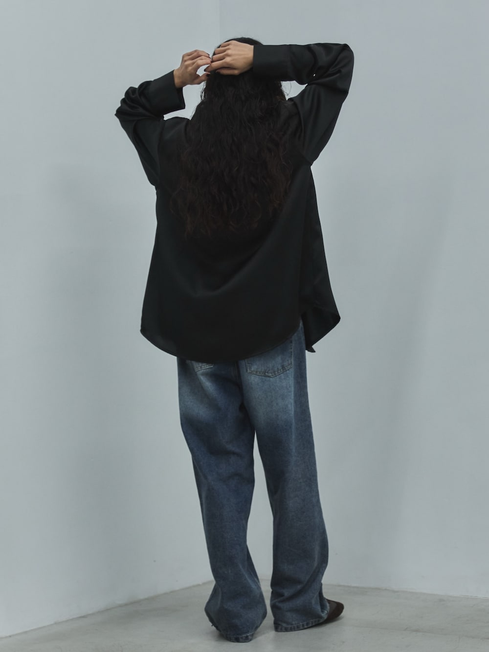 ブラック系のシャツ/ブラウス、ブルー系のデニムパンツ、ブラウン系のスニーカーを着用したレディースの秋コーディネートの3枚目の写真