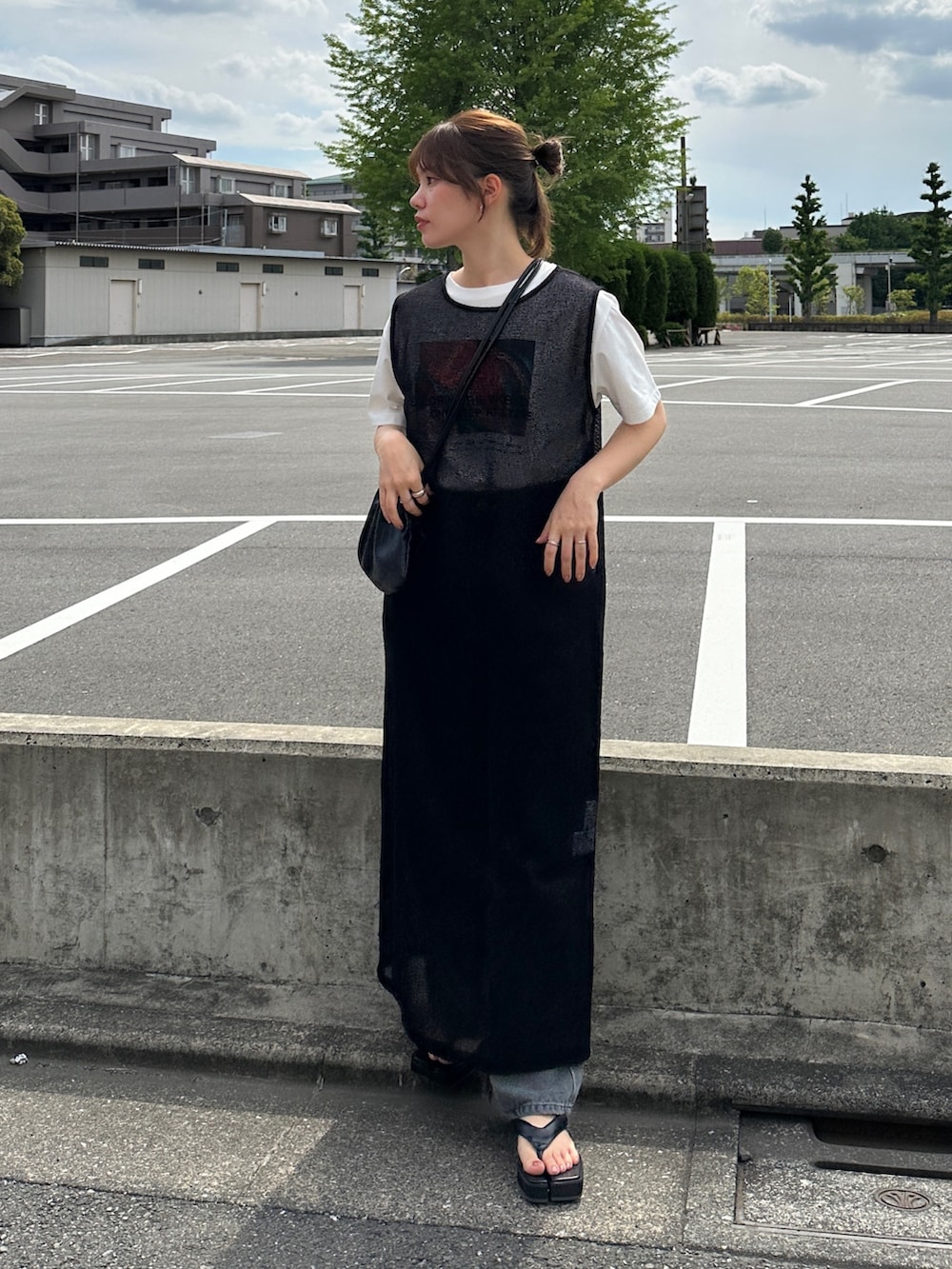 ブラック系のワンピース、グレー系のデニムパンツ、ブラック系のショルダーバッグを着用したレディースの夏コーディネートの2枚目の写真