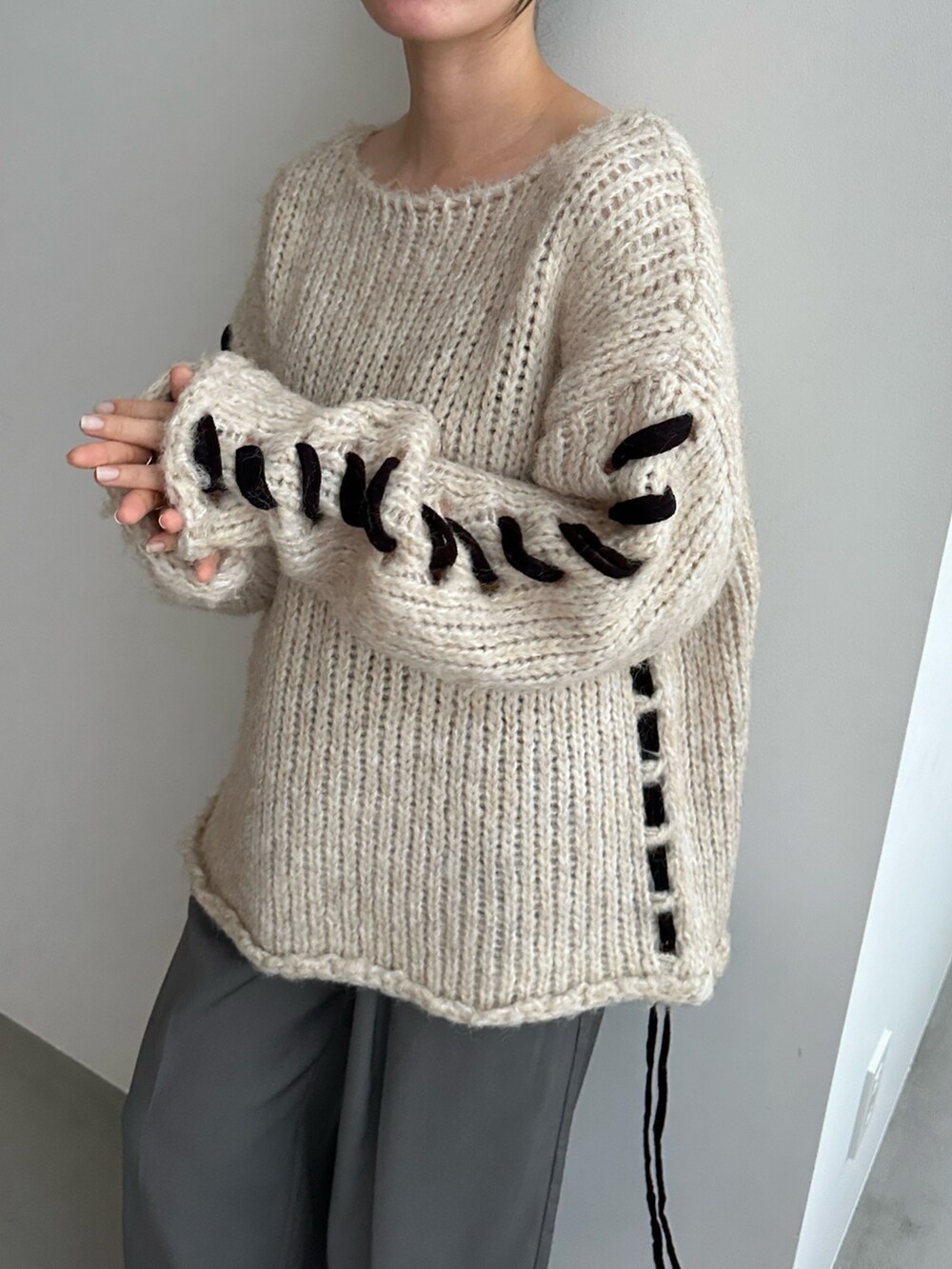 ホワイト系のニット/セーター、ブラック系のスラックスを着用したレディースの秋コーディネートの4枚目の写真