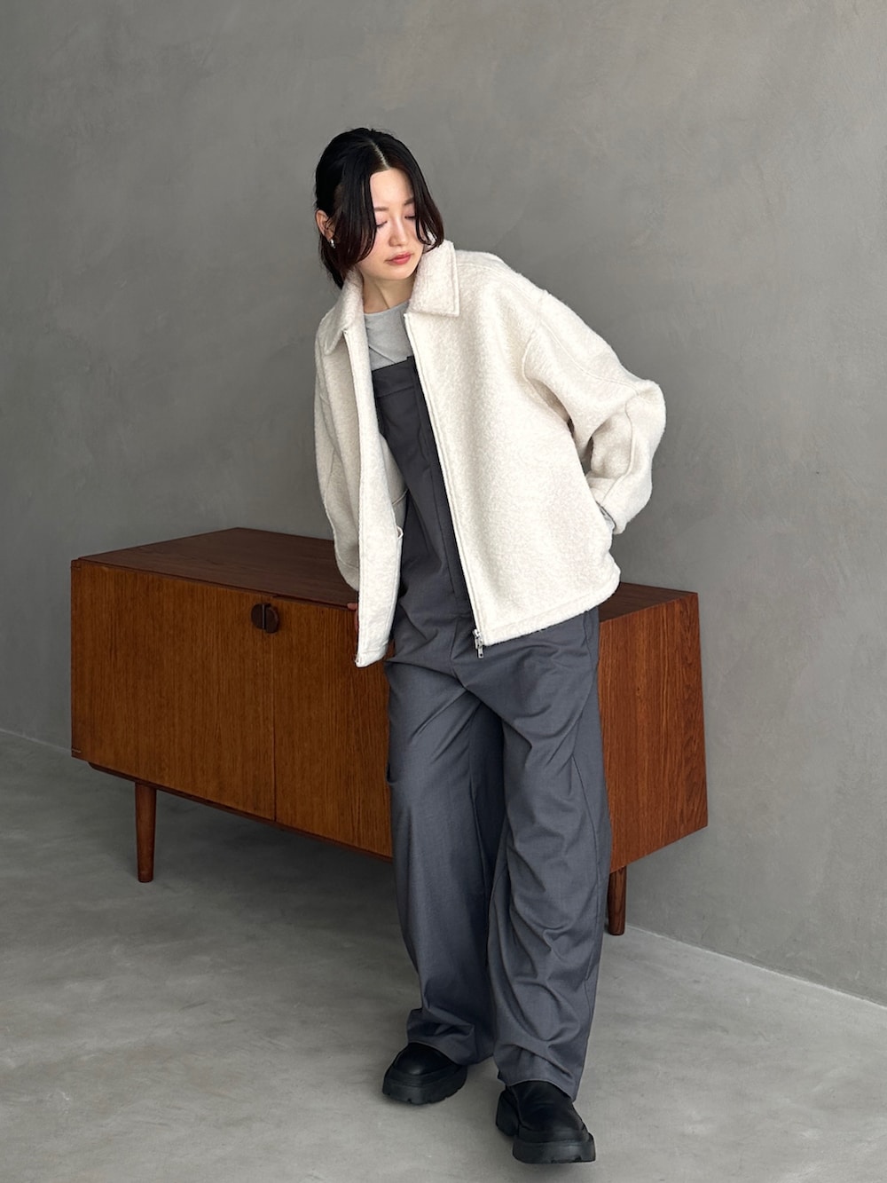 ホワイト系のブルゾン、シルバー系のTシャツ/カットソー、グレー系のサロペット/オーバーオールを着用したレディースの秋コーディネートの2枚目の写真