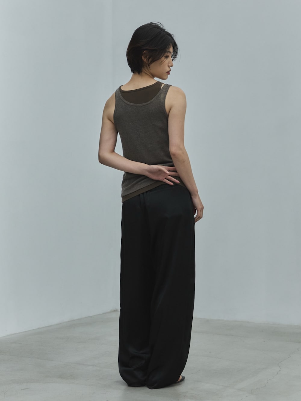グレー系のタンクトップ、ブラック系のその他パンツ、ブラック系のサンダルを着用したレディースの夏コーディネートの3枚目の写真