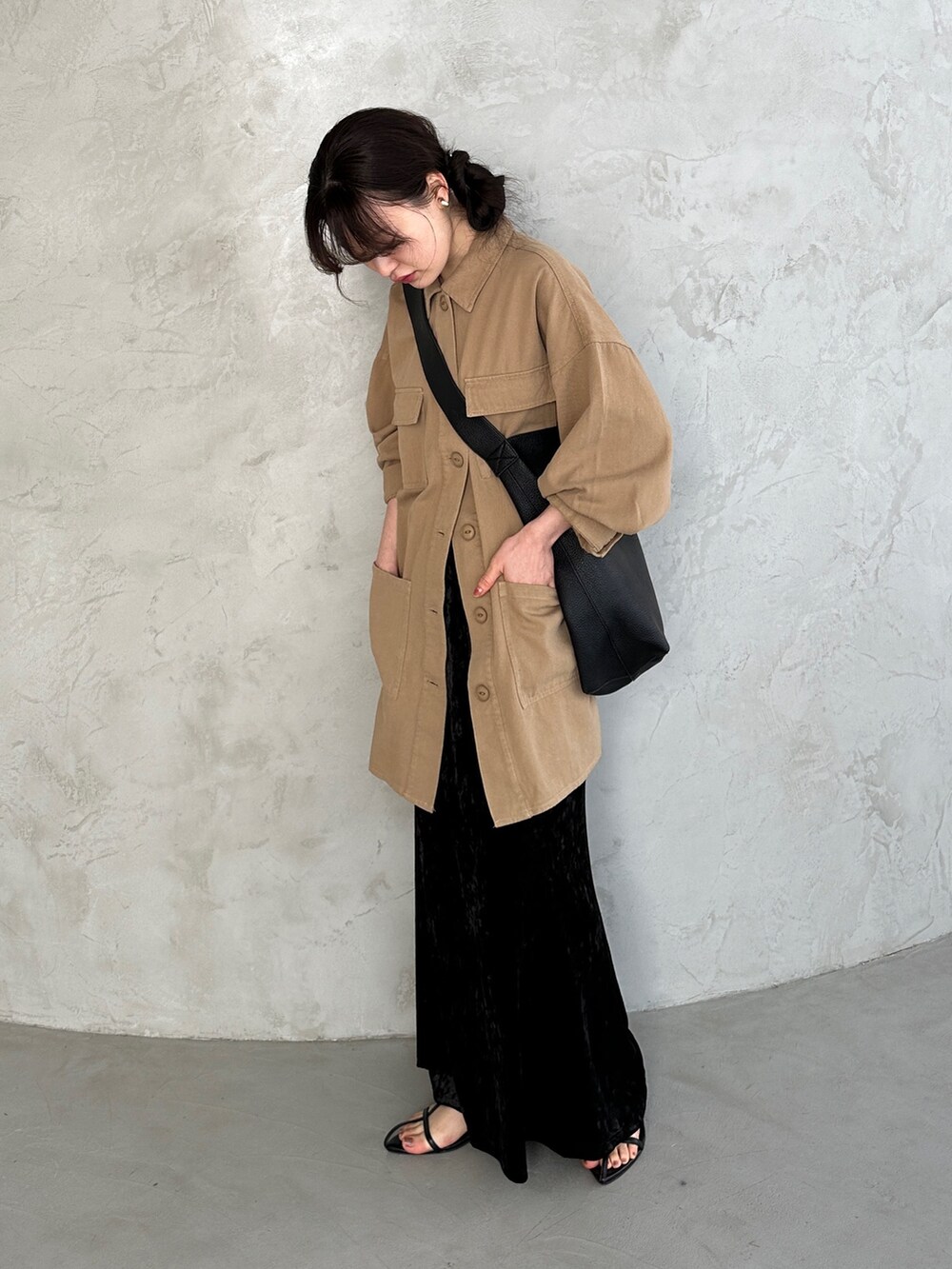 ブラック系のショルダーバッグ、ブラック系のスカート、ベージュ系のミリタリージャケットを着用したレディースの春コーディネートの2枚目の写真