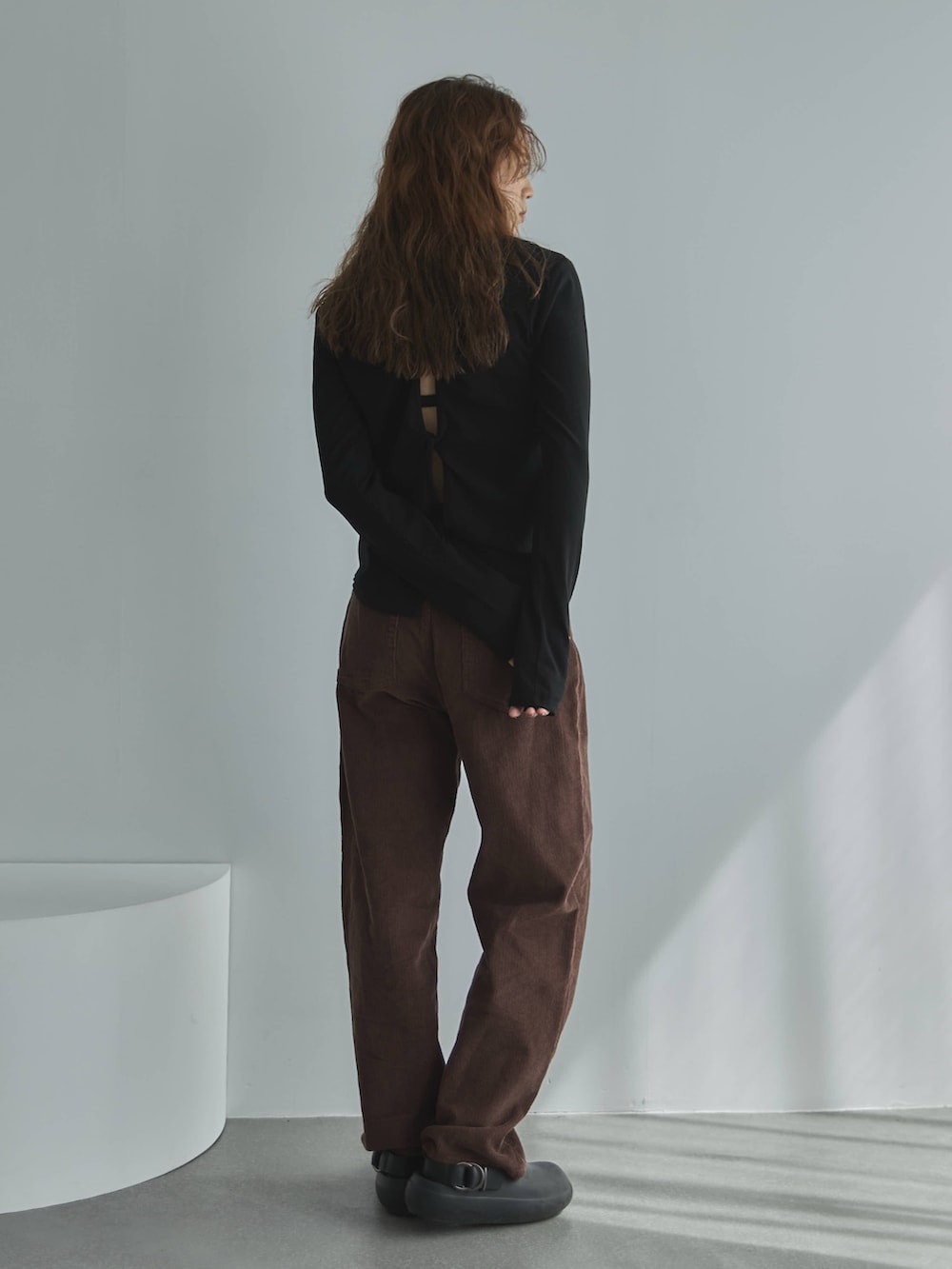 ブラック系のTシャツ/カットソー、ブラウン系のその他パンツ、ブラック系のサンダルを着用したレディースの秋コーディネートの2枚目の写真