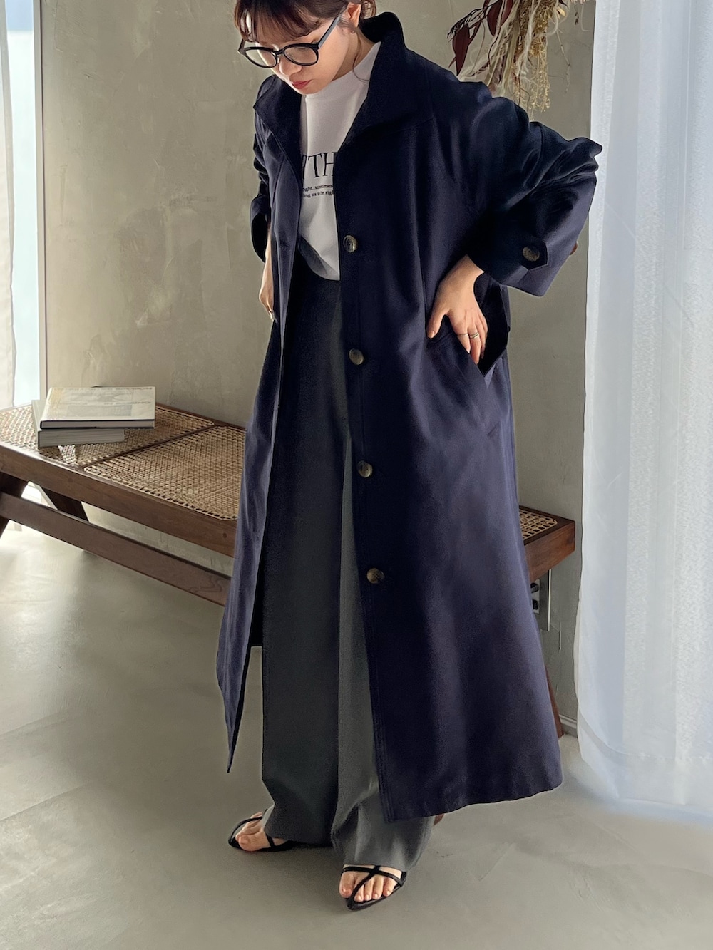 ブルー系のトレンチコート、ホワイト系のスウェット、グレー系のスラックスを着用したレディースの冬コーディネートの2枚目の写真