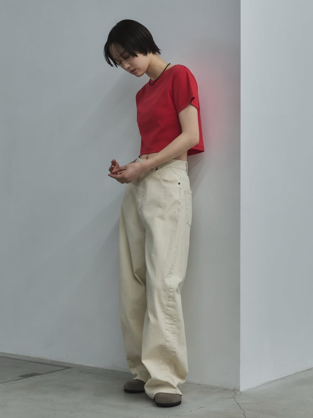 レッド系のTシャツ/カットソー、ホワイト系のデニムパンツ、ベージュ系のサンダルを着用したレディースの春コーディネートの3枚目の写真