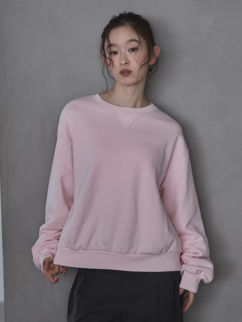 ピンク系のスウェット、グレー系のスラックス、ブラック系のその他シューズを着用したレディースの春コーディネートの4枚目の写真