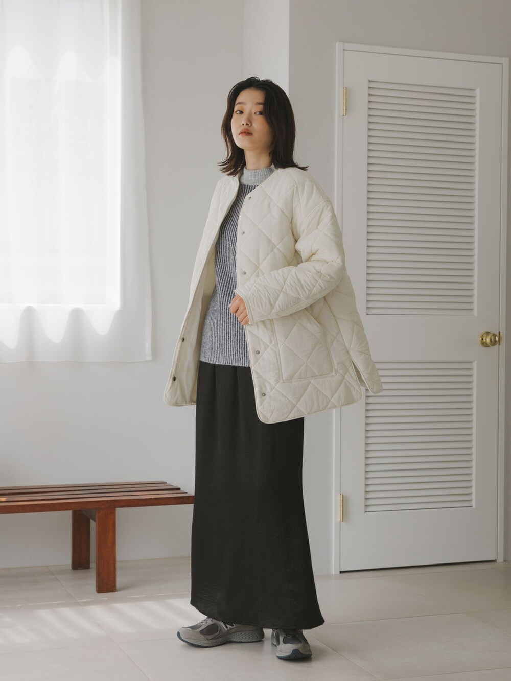 グレー系のスニーカー、ブラック系のスカート、グレー系のニット/セーターを着用したレディースの秋コーディネートの3枚目の写真