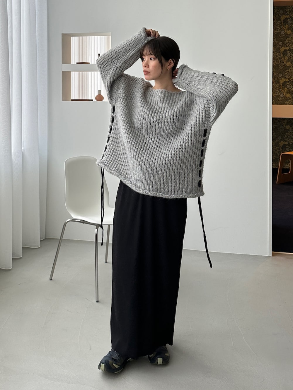 グレー系のニット/セーター、ブラック系のスカート、グリーン系のスニーカーを着用したレディースの秋コーディネートの3枚目の写真