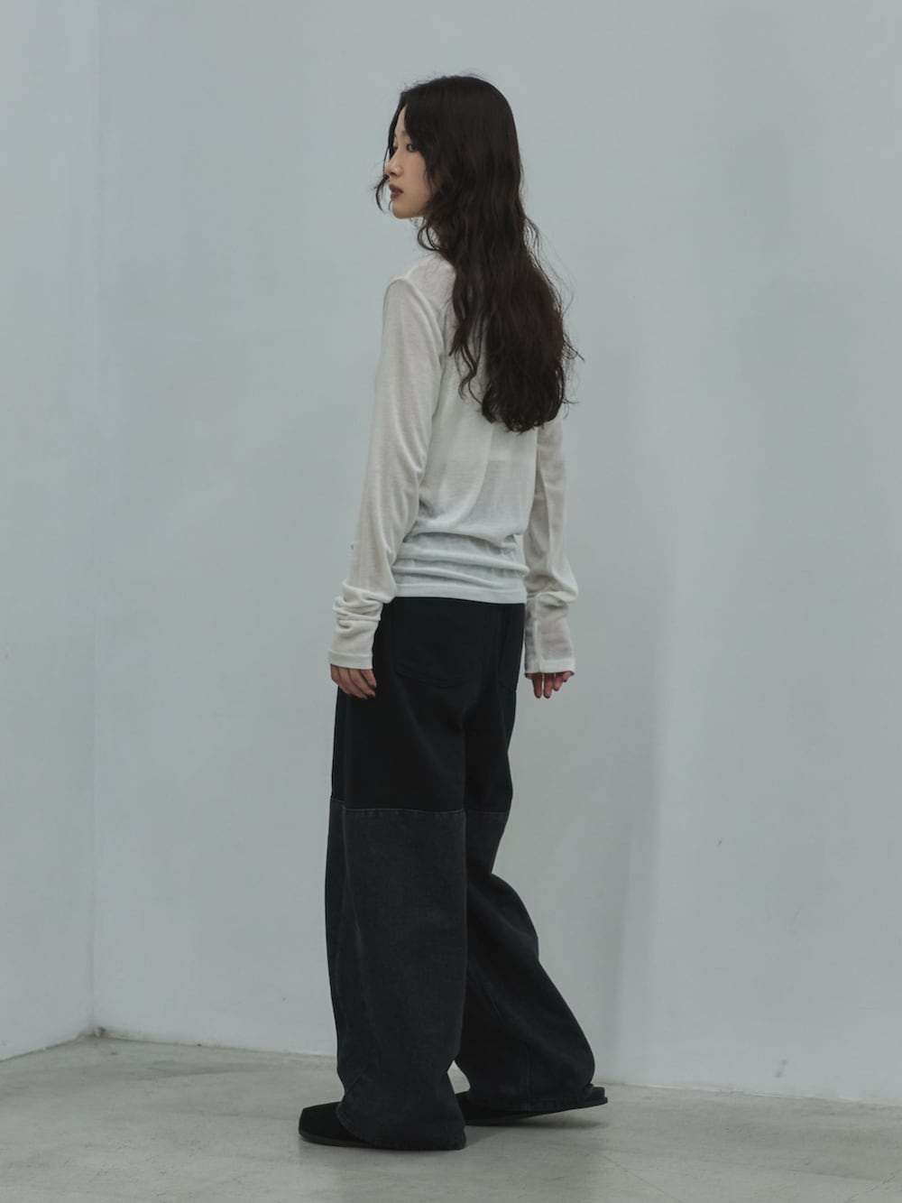 ホワイト系のキャミソール、ホワイト系のTシャツ/カットソー、ブラック系のデニムパンツを着用したレディースの秋コーディネートの2枚目の写真