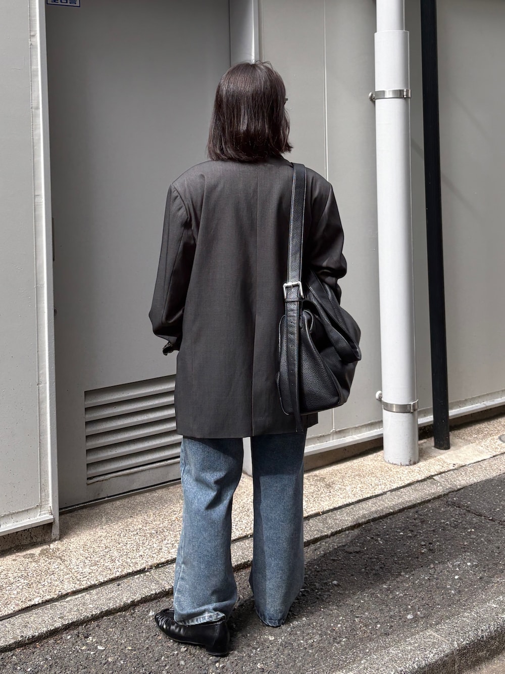 グレー系のテーラードジャケット、ホワイト系のTシャツ/カットソー、ブルー系のデニムパンツを着用したレディースの春コーディネートの4枚目の写真