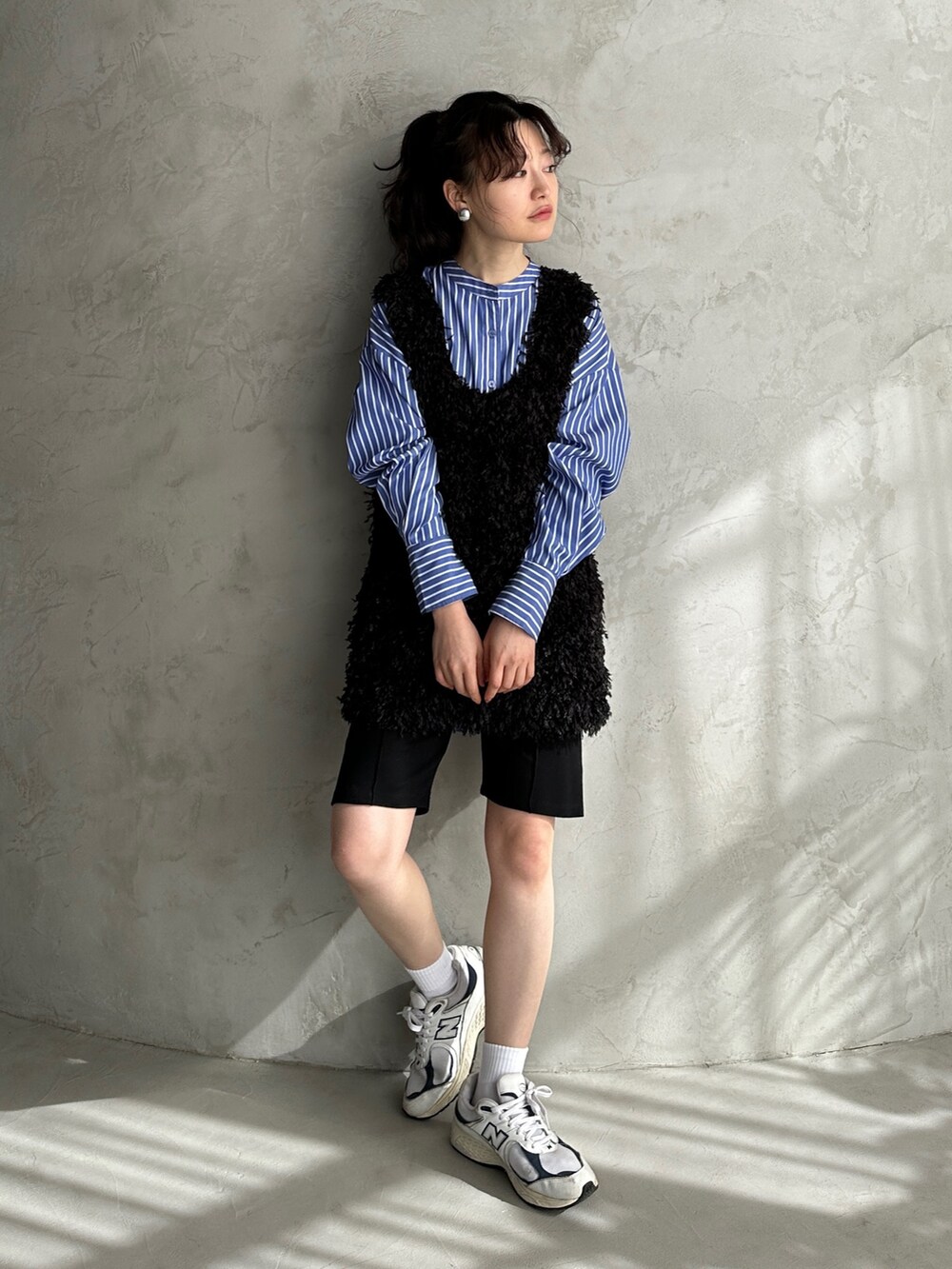 ブラック系のベスト、ブルー系のシャツ/ブラウス、ブラック系のその他パンツを着用したレディースの春コーディネートの2枚目の写真