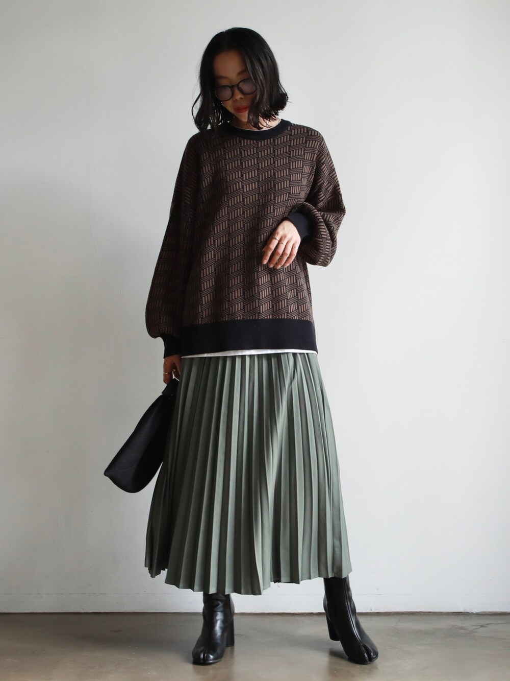 グリーン系のカーディガン/ボレロ、その他のショルダーバッグ、ホワイト系のニット/セーターを着用したレディースの冬コーディネートの3枚目の写真