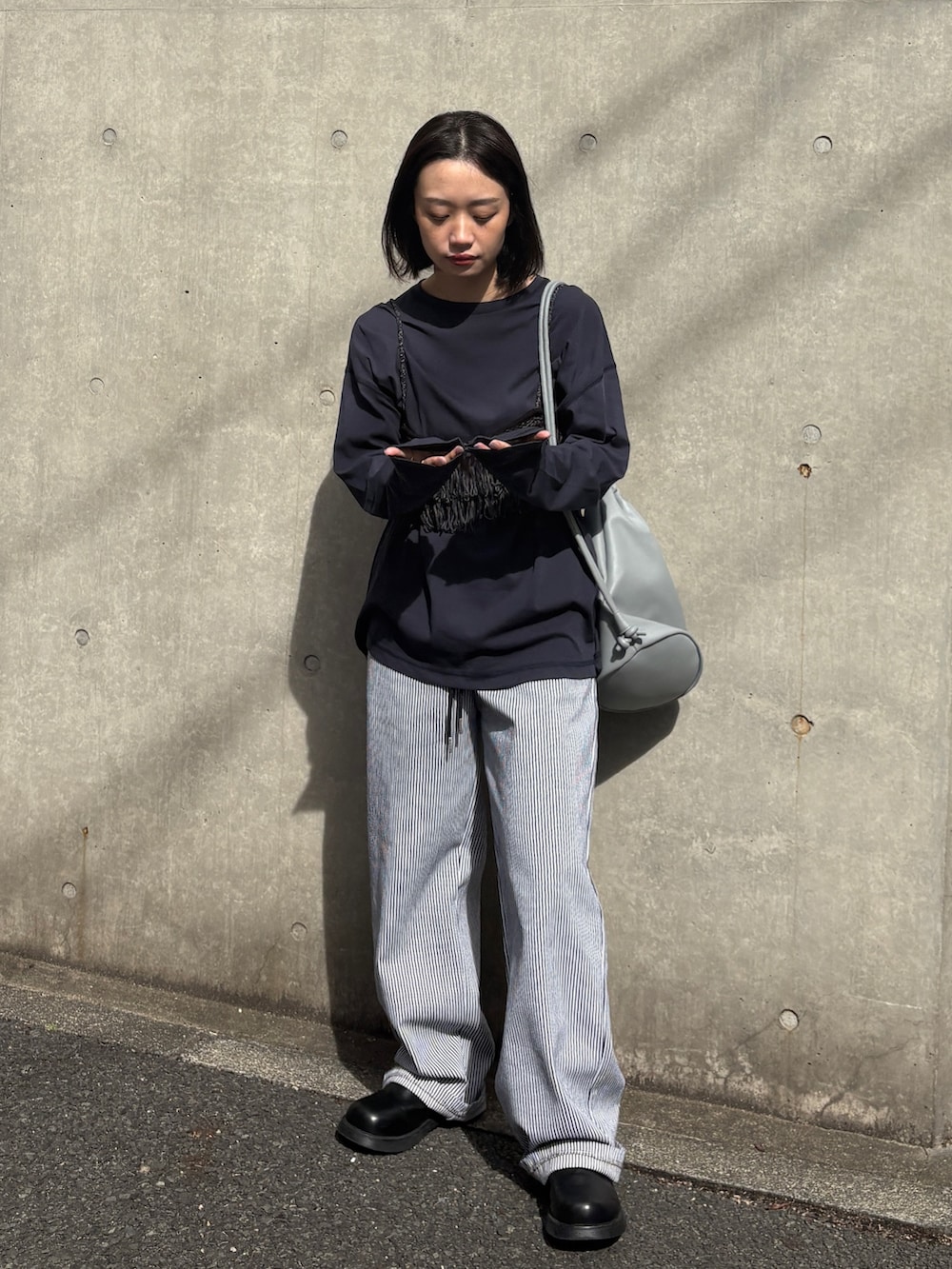 ホワイト系のデニムパンツ、ブラック系のその他シューズ、ブルー系のTシャツ/カットソーを着用したレディースの春コーディネートの4枚目の写真