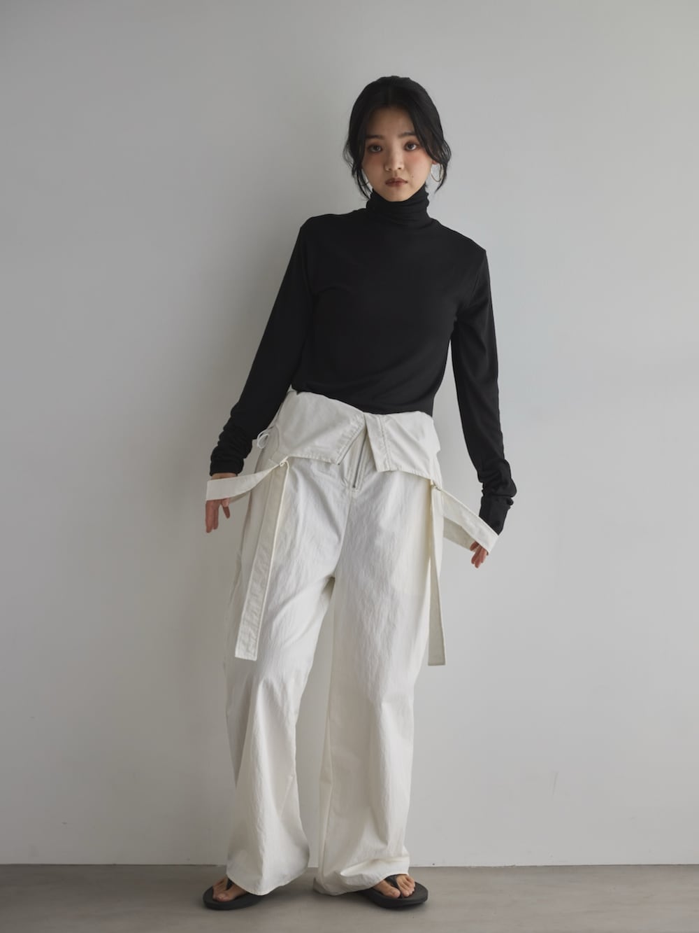 ブラック系のTシャツ/カットソー、ブラック系のサンダル、ホワイト系のサロペット/オーバーオールを着用したレディースの春コーディネートの2枚目の写真