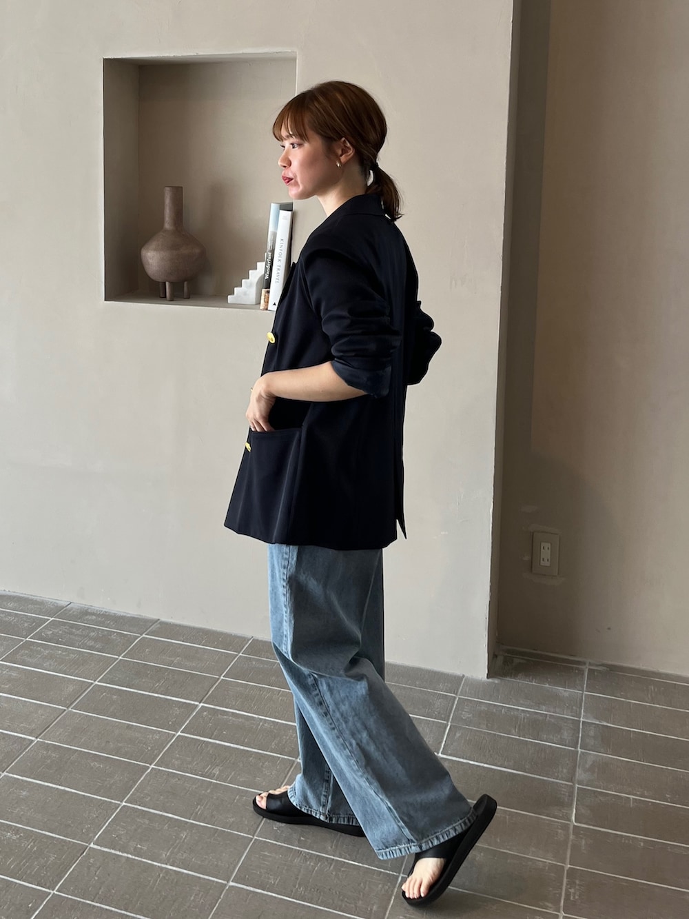 ブルー系のテーラードジャケット、ベージュ系のタンクトップ、グレー系のスラックスを着用したレディースの春コーディネートの4枚目の写真