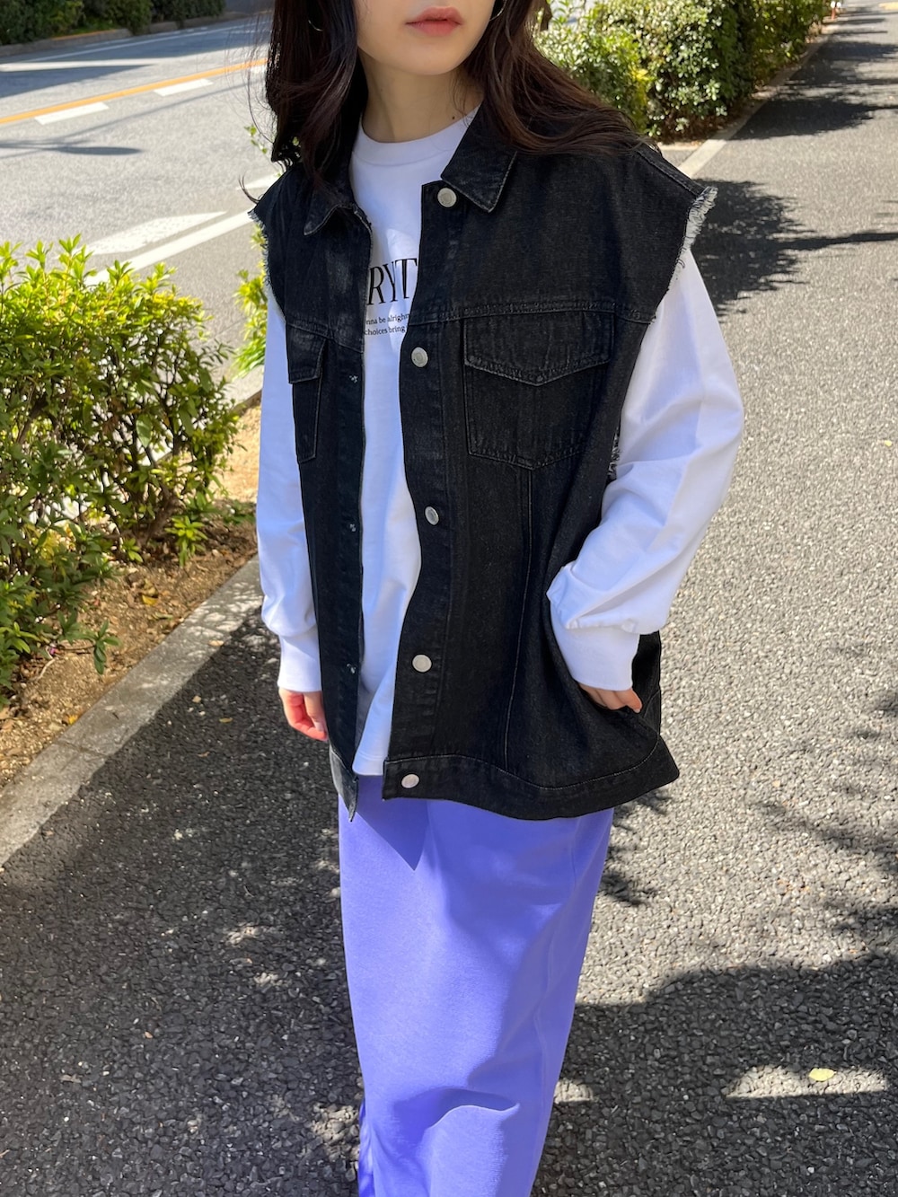 ブラック系のベスト、ホワイト系のスウェット、パープル系のスカートを着用したレディースの春コーディネートの4枚目の写真