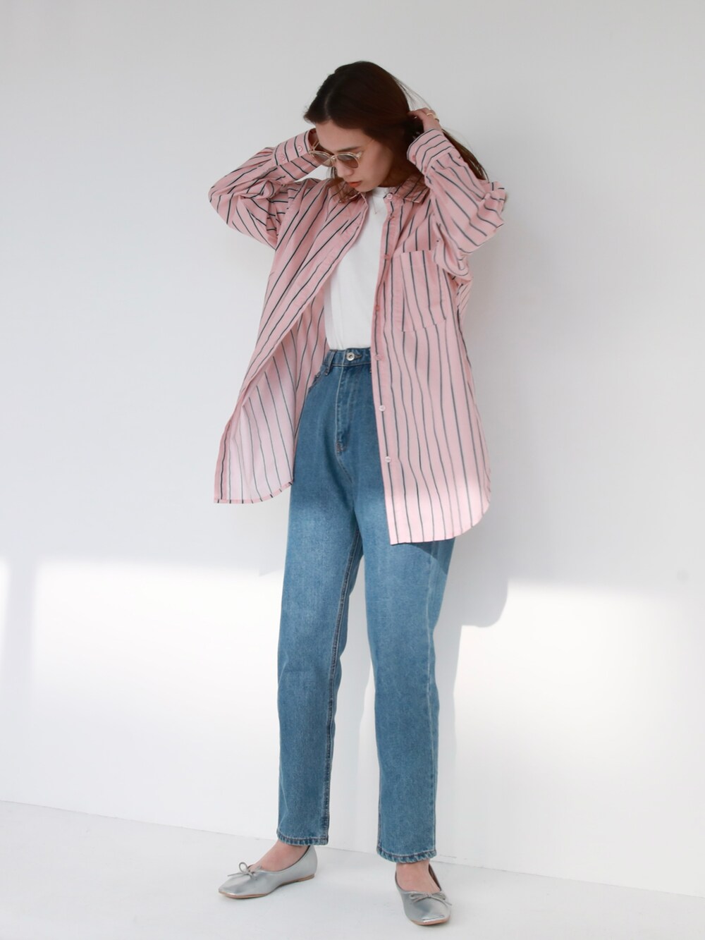 ブラック系のハンドバッグ、ブルー系のデニムパンツ、ピンク系のシャツ/ブラウスを着用したレディースの冬コーディネートの2枚目の写真