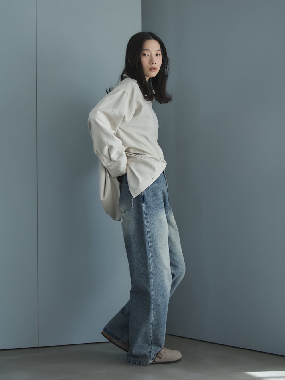 ブルー系のデニムパンツ、ホワイト系のシャツ/ブラウス、ベージュ系のサンダルを着用したレディースの春コーディネートの3枚目の写真