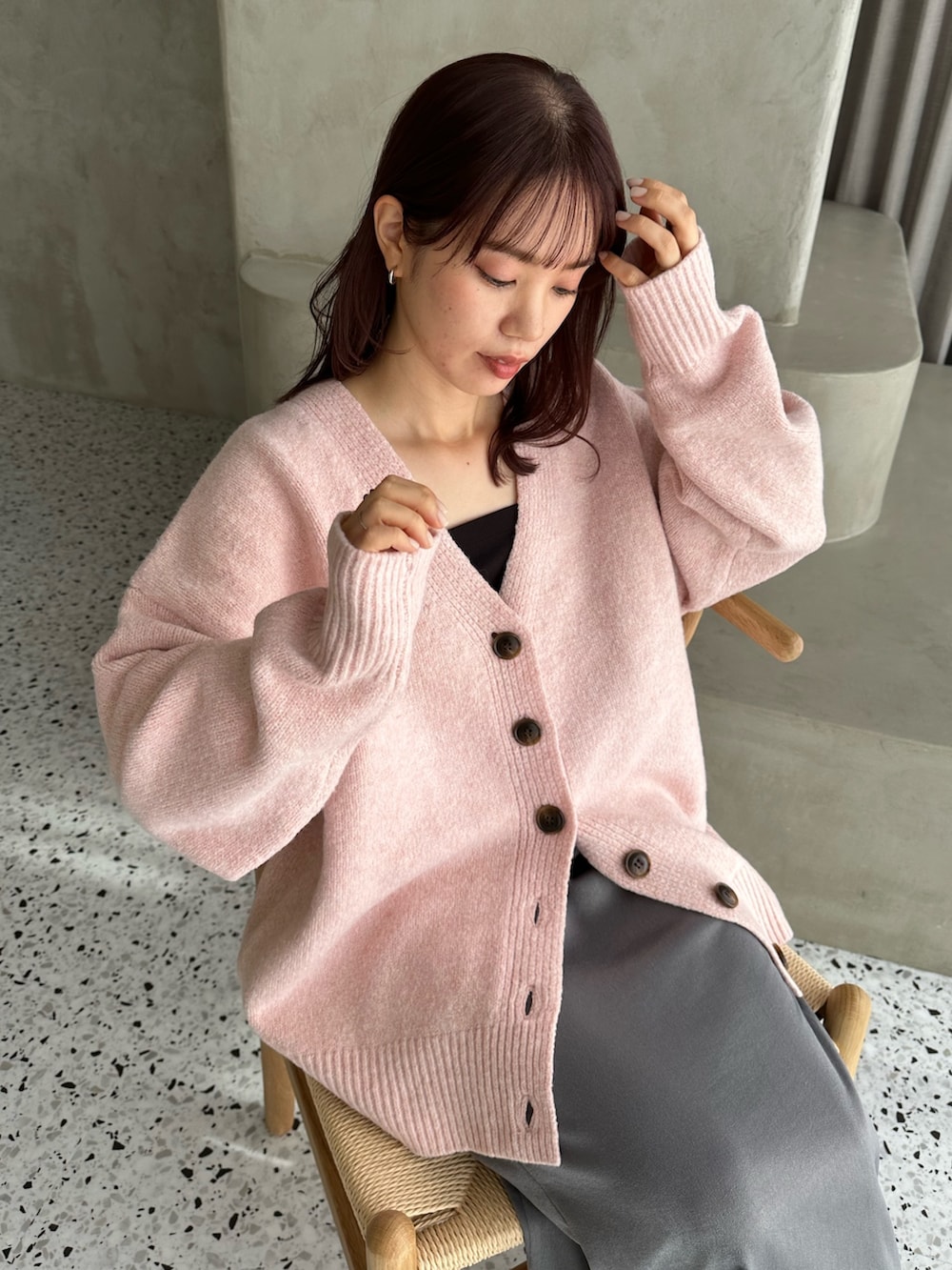 ピンク系のカーディガン/ボレロ、グレー系のスカート、ホワイト系のスニーカーを着用したレディースの冬コーディネートの4枚目の写真