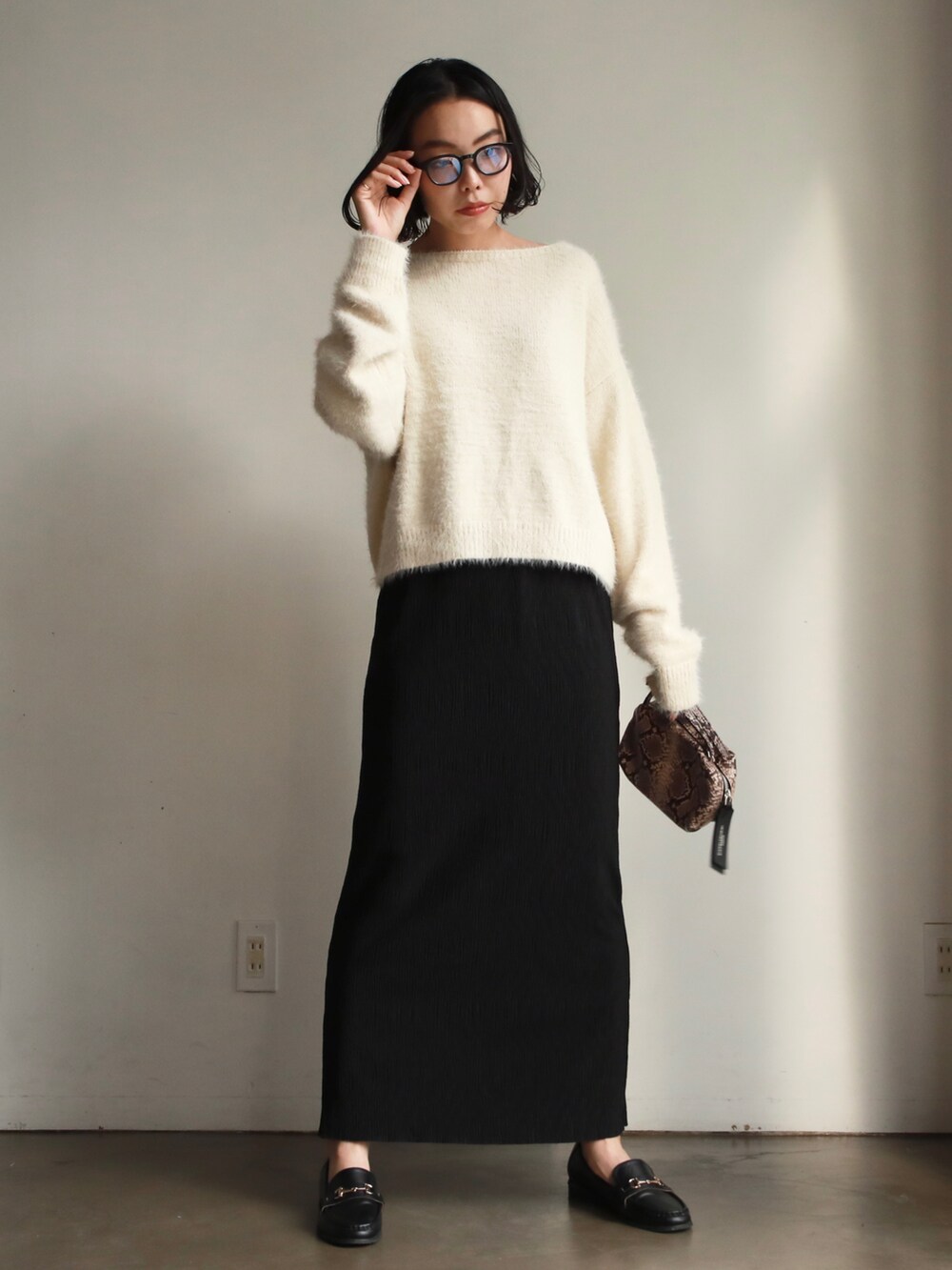 グレー系のスカート、ブルー系のTシャツ/カットソー、ブラック系のニット/セーターを着用したレディースの冬コーディネートの4枚目の写真